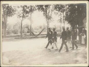 Kaiser Wilhelm II. mit Begleitern in Uniform beim Spaziergang.