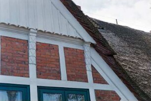 Möllner Landstraße (3): Fachwerkhaus mit Reetdach: Traufseite: Zwerchgiebel, Detailaufnahme: vorkragende Verbretterung, Schnitzwerk