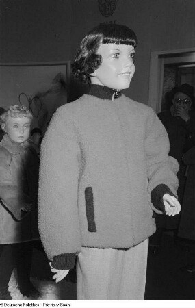 Jacke aus rotem Marionspastel und andere Kindermode an Schaufensterpuppen auf der Leipziger Frühjahrsmesse
