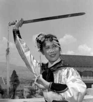 Portrait einer Schwerttänzerin in Bewegung und traditioneller Kleidung