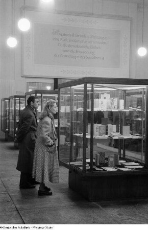 Besucher betrachten die in Vitrinen ausgestellten Exponate bei der 2. Deutschen Buchkunst-Ausstellung
