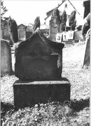 Grabstein 319 (Index: 99786307) Zustand: obere Hälfte auf Sockel zementiert, Vorderseite vollständig abgeblättert Maße HxBxT: 110x67x23 cm: Grabstein 319