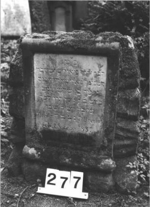 Grabstein 277 (Index: 100082283) Material: Granit, weiße Marmorplatte Zustand: gut Maße HxBxT: 65x56x41 cm Beschreibung: Stele, rustica, Schriftfeld in Pergamentrollenform, rechteckige Schriftplatte Symbolik: Pergamentrolle: Grabstein 277