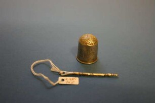Fingerhut und Nadel (Fingerhut und Näh-/Stopfnadel)