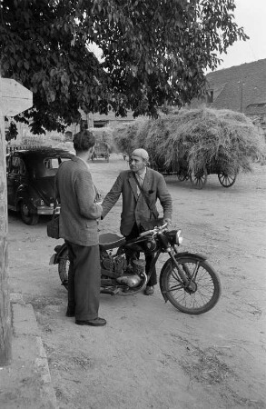 Jahna. Drei Männer im Gespräch (einer davon mit Motorrad)