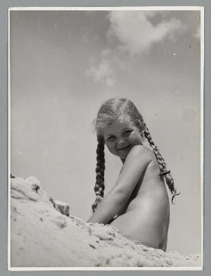 Nacktes Mädchen sitzt am Strand