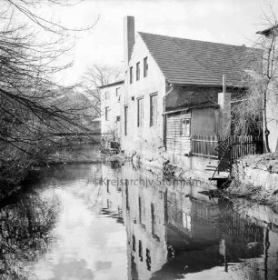 Trave: Stadtarm: hinten links Brücke hinter Bäumen: rechts Gebäude