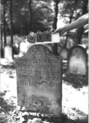 Grabstein 312 (Index: 99609949) Material: Sandstein Zustand: stark verwittert, teilweise Textverlust Maße HxBxT: 94x52x8 cm Beschreibung: Stele, Konvexbogenabschluß, Schriftfeld eingetieft: Grabstein 312