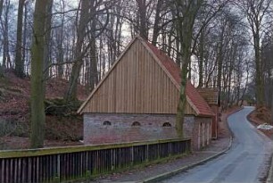 Nütschau: Schloßstraße 44: gegenüber von ehemaliger Kornwassermühle: Pferdestall, Giebelseite mit Verbretterung, Straßenfront: Blick von Nordosten: dahinter Backhaus [halb verdeckt]: hinten Wald: im Vordergrund Brücke über die Trave