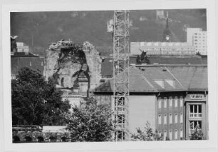 Blick auf die Ruine der Frauenkirche (Chorapsis), im Vordergrund links eine Grundmauer der Ruine des Taschenbergpalais, im Hintergrund der Turm der Trinitatiskirche (Johannstadt) und die Bergstation der Schwebeseilbahn in Loschwitz