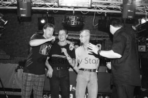 Schützenverein: Männerversteigerung: Exer, Festzelt: drei Kandidaten auf Bühne, mit Moderator Thorsten Stührk [Rückenansicht]: 26. Juli 1998