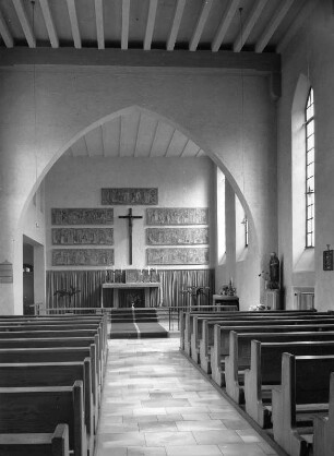 Inneres einer kleinen modernen Kirche. Blick zum Altar mit Kruzifix und Fries