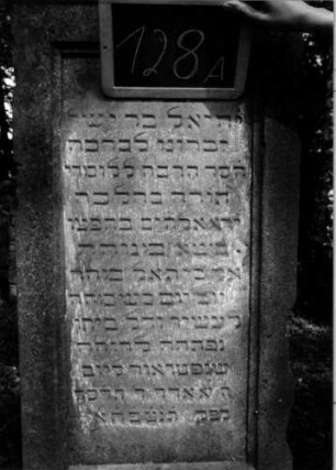 Grabstein 128 (Index: 100111262) Material: Sandstein Zustand: leicht verwittert mit Textverlust, beschädigt Maße HxBxT: 194x60x49 cm Beschreibung: Stele, getreppter Sockel, Abdeckplatte mit Volutenaufsatz, rechteckige Schriftfelder eingetieft Symbolik: Blüten, Voluten: Grabstein 128A