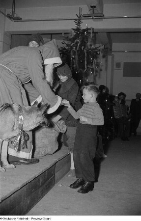 Blick auf die Bühne mit Weihnachtsmann, ein Geschenk überreichend