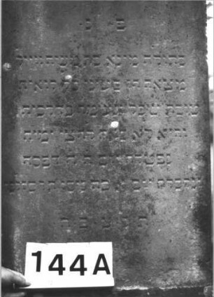 Grabstein 144 (Index: 99898969) Material: Sandstein Zustand: angewittert Maße HxBxT: 171x59x23 cm Beschreibung: aufgesockelte Stele mit Konvexbogenabschluss, oben abgeflacht und mit Voluten und über den Rand hängender Palmette, unterer Sockel felsartig gearbeitet Symbolik: Palmette, Voluten: Grabstein 144A