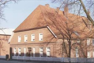 Poststraße (1): giebelständiges Backsteinhaus: Straßenfront mit Eingangstür und Fenstern, Traufseite: davor Gartenzaun