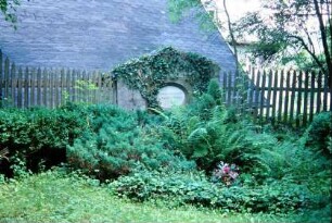 einzelne Grabstätte am Holzzaun des Friedhofes