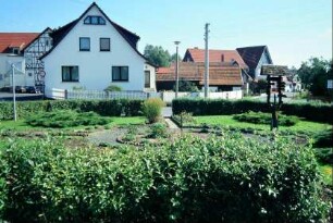 kleine Grünanlage mit Wanderwegweiserbaum