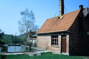 Backhaus am Dorfplatz, Backsteinbau; daneben Teich