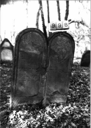 Grabstein 998 (Index: 99751341) Material: Sandstein Zustand: abgeblättert mit Textverlust Maße HxBxT: 113x79x10 cm Beschreibung: Doppelstele, zwei Schriftfelder eingetieft Besonderheit: Zitat 2.Samuel 1, 23: Grabstein 998