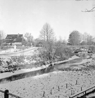 Bille: im Hintergrund rechts Betonbücke: hinten links Reetdachhaus: Winter