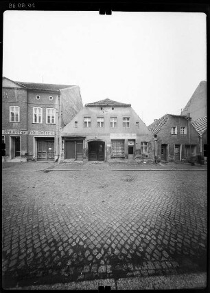 Luckau, Lange Straße. Wohnhaus mit Läden. Straßenfront