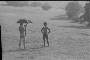 Čičmany. Akt-Pleinair 1980. Günter Rössler (unter einem Schirm) fotografiert eine stehende junge Frau