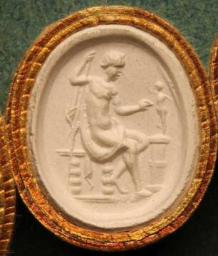 Sitzender Mann mit Spieß vor einer bewaffnete Statuette (Daktyliothek, Supplement)