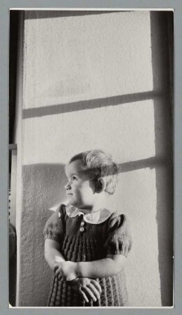 Portrait eines Kleinkindes durch ein Fenster blickend