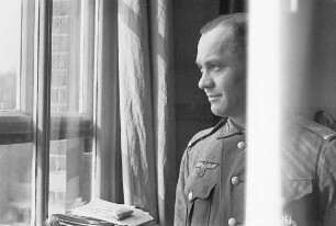 Zweiter Weltkrieg. Niederlande unter deutscher Besatzung. Deutscher Wehrmachtsangehöriger am Fenster eines Dienstzimmers (wohl bei Den Haag)