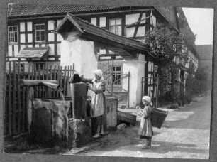 Am Brunnen in Breternitz bei Saalfeld : Breternitz. Frau und Kind an einem Brunnen Wasser schöpfend