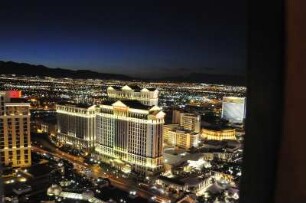 Nächtliches Las Vegas mit Caesars Palace Hotel : Blick vom Nachbau des Pariser Eiffelturms am Las Vegas Boulevard auf das am Abend beleuchtete Las Vegas, aufgenommen am 8. August 2012