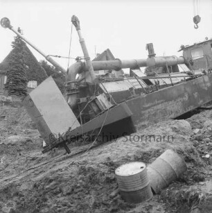 Ratzeburger Straße: Moorloch an abgesackter Straße: Bergung eines Baggers: in der Mitte Schwimmbagger auf Böschung: vorn zwei Tonnen: hinten Häuser: 02.08.1974