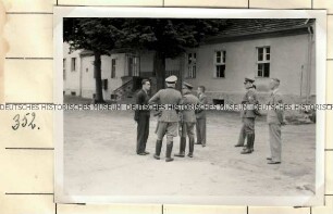 Angehörige der Ordnungspolizei mit japanischen Besuchern auf einem Innenhof vor einem Gebäude