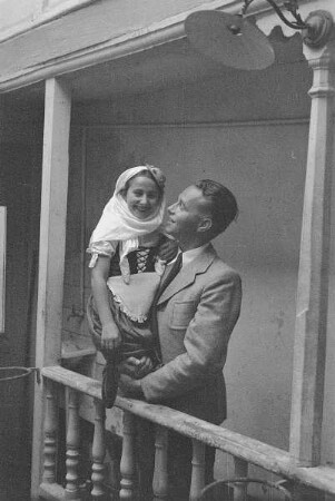 Reisefotos Spanien. Franz Grasser mit kleinem spanischen Mädchen in Tracht auf dem Arm auf einer Innenhofgalerie