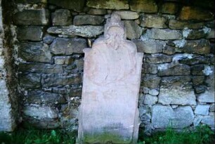 alter Grabstein an der Friedhofsmauer
