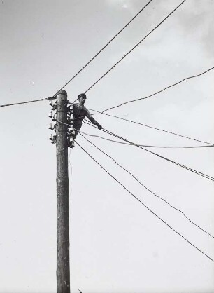 Telegrafenarbeiter bei der Arbeit am Mast