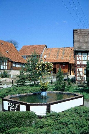 mit Osterschmuck versehener Dorfbrunnen, Brunnen mit Jahreszahl 1973