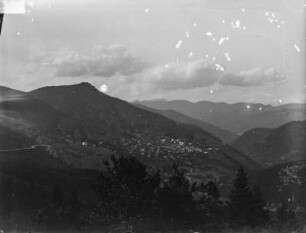 Bergdorf : Blick über ein Gebirge mit einem Bergdorf an einem Berghang