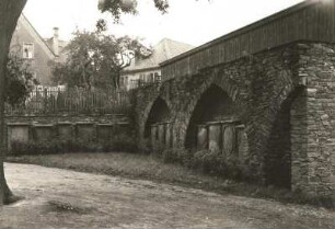 Döbeln, Lutherplatz (hinter der Nikolaikirche). Nordöstlicher Rest der Stadtmauer mit aufgestellten Grabsteinen