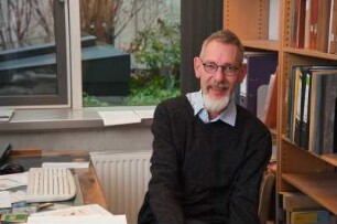 Porträt Perk Loesch, Fachreferent der SLUB : Porträt des Kunstwissenschaftlers Perk Loesch, Fachreferent und von 1996 bis 2019 Leiter der Handschriftenabteilung an der Sächsischen Landesbibliothek – Staats- und Universitätsbibliothek Dresden (SLUB). Aufnahme an seinem Schreibtisch