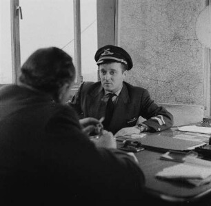 Schönefeld. Flughafen Berlin-Schönefeld. Diensteinweisung eines Piloten am Schreibtisch eines Verantwortlichen