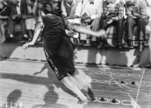 Freizeitgestaltung : Frau bei einem Spiel vor einer besetzten Tribüne am Deck eines Schiffes