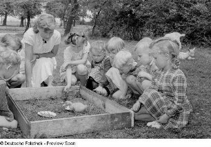 Kinder beim Beobachten eines Entenkükens