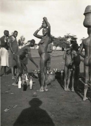 Ostafrika. Afrikaner (wahrscheinlich aus Volksgruppe der Tutsi, früher Watussi genannt). Frauen Flaschen in Körben auf dem Kopf tragend