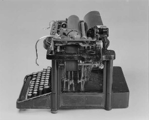 Typenhebelschreibmaschine "Remington" (Modell 5). Unteranschlag (nicht sofort sichtbare Schrift), Universaltastatur mit 42 Tasten, 36-mm-Farbband. Seitenansicht von rechts oben
