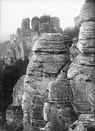 Sächsische Schweiz, Rathener Gebiet. Raaber Kessel nördlich von Rathen. Höllenhundspitze. Seilschaft K. Jander in den Rißfolgen des Alten Weges. Blick auf Große Gansscheibe und Kleinen Gansfels