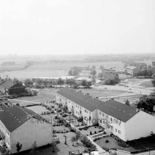 Gartenstadt Falkenberg: Wohngebäude der Greifswalder Kehre, dahinter die Straße Am Exerzierplatz, dahinter links der Sportplatz, mittig das Sportlerheim und rechts daneben die Schulgebäude der Volksschule (Gemeinschaftsschule) Harksheide: Blick vom Rathausgebäude Richtung Süden