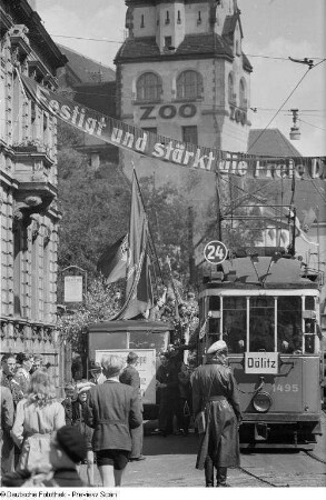 Geschmückte Straße vor der Kongreßhalle, Passanten, Straßenbahn