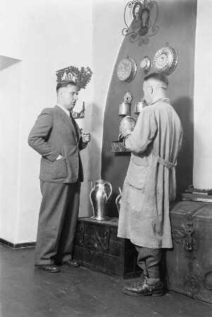 Dresden, Köpckestraße 1: Museum für Sächsische Volkskunst mit Puppentheatersammlung (1927-1949 Oskar-Seyffert-Museum), Ausstellung Erdgeschoßhalle nach Rücktransport der ab 1942 in Schloss Weesenstein eingelagerten Bestände. Mitarbeiter vor Nische mit Truhen, Haushaltsgeräten und Kupfergefäßen